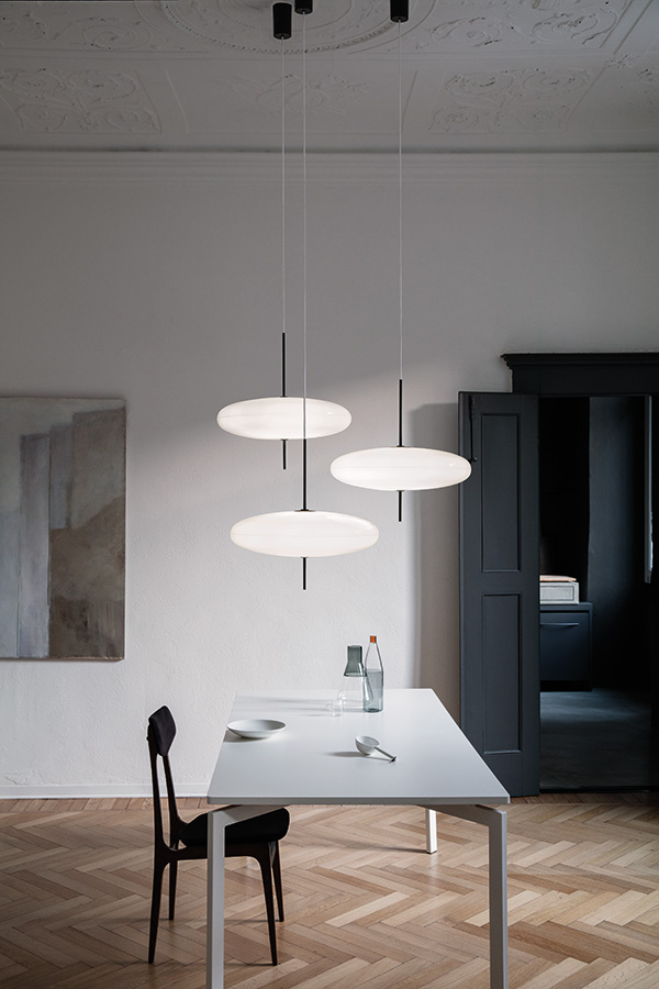A collection of three Astep 2065 pendants above a dining table