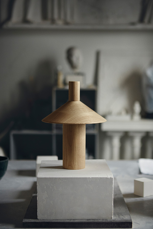 The wooden Pepa Table Lamp on a concrete block in a studio