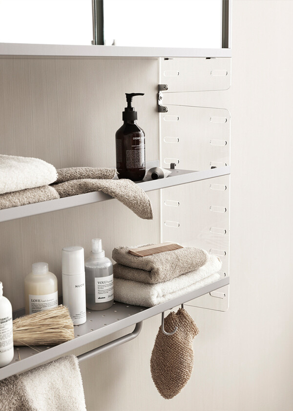 The String Pocket Metal in grey in a bathroom, holding bathroom accessories.