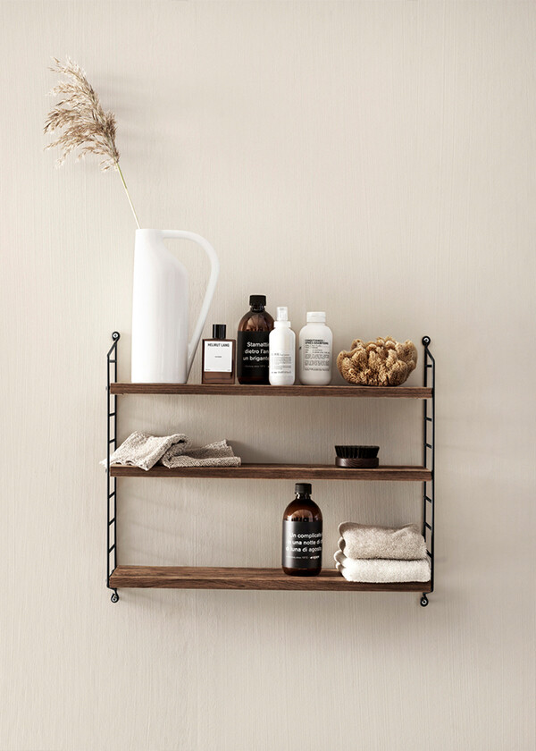 The String Pocket in dark wood, holding bathroom accessories.