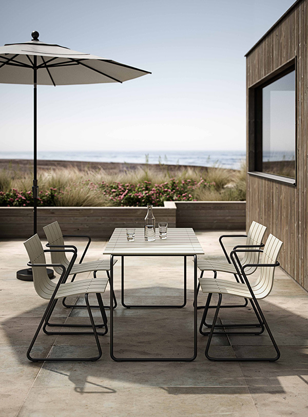 The Mater Ocean Outdoor Table and Chairs on a terrace near the beach