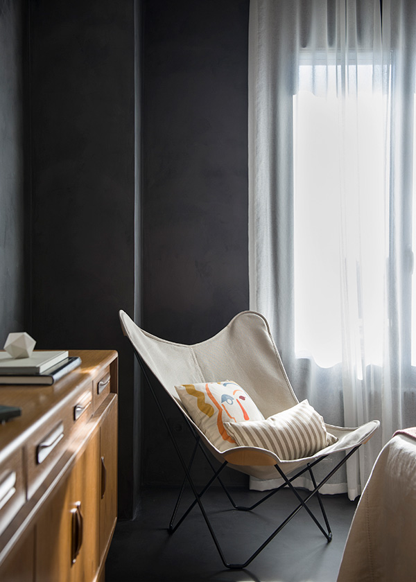 Canvas Mariposa Chair with cushions in a dark bedroom