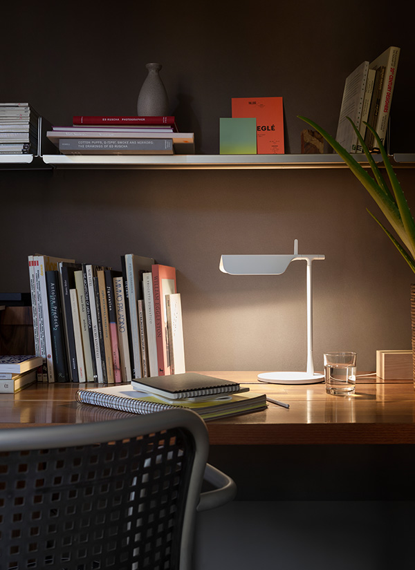 White Flos Tab Table Lamp on a desk next to some books