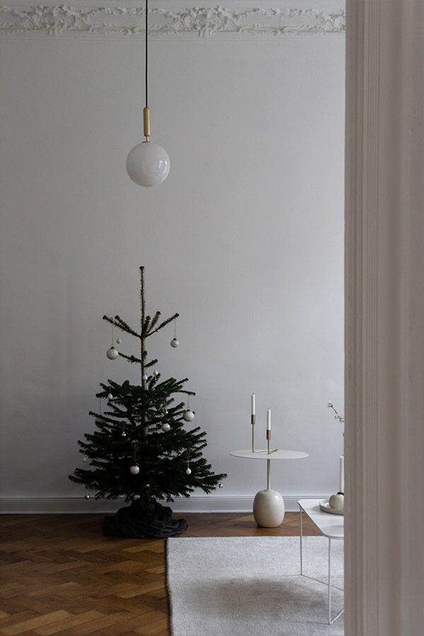 a minimal interior with a small Christmas tree and the &tradition lato table