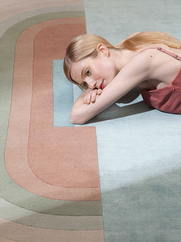 Woman laying on the cc-tapis Giudecca Rug