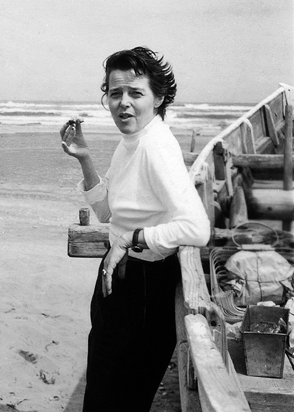 A black and white photo of Charlotte Perriand next to a boat