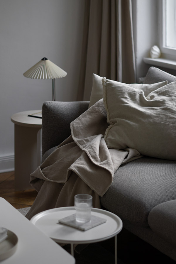 HAY Matin Table Lamp on a side table next to a grey sofa