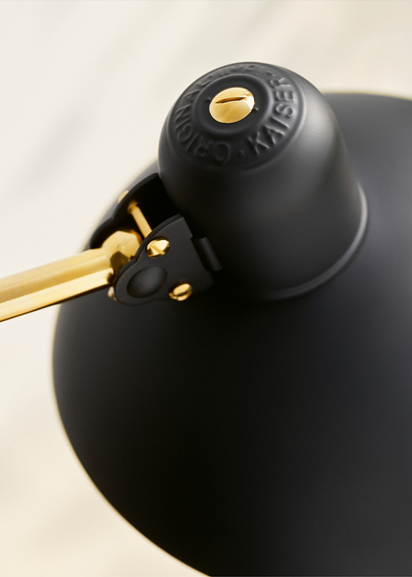 A detail shot of the Kaiser Idell 6631-T Luxus Table Lamp - Special Edition Brass with branding at the top