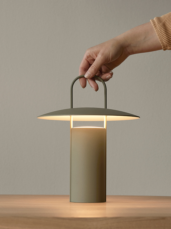 Hand holding Audo Copenhagen Ray Portable Table Lamp
