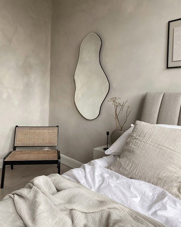 A Ferm Living pond mirror in a neutral bedroom