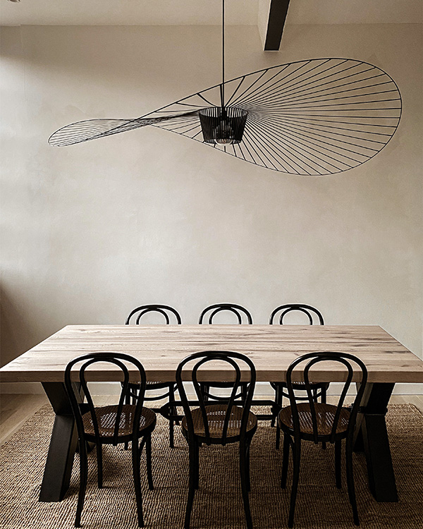 A dining table with a Petite Friture vertigo pendant above it