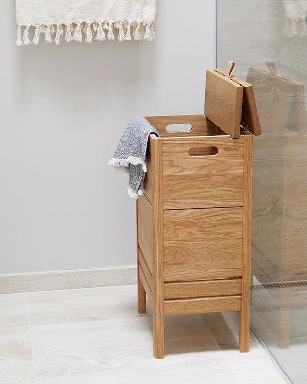 A Form & Refine wooden laundry box with a folding lid