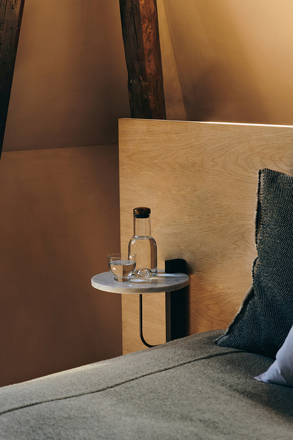 Audo Corbel Shelf used as a bedside table in a warm minimal bedroom