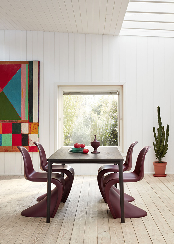 4 dark purple Vitra Panton Chairs around a black dining table