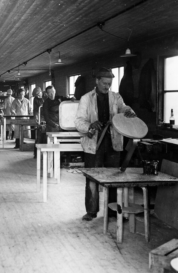 Archive photograph of workers assembling the Stool 60 in the Artek factory
