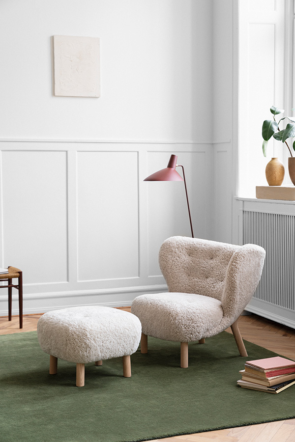 A little Petra lounge chair and pouf on a green rug