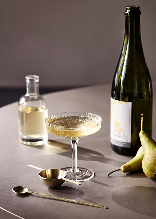 Ferm Living Ripple Champagne Glass filled with the Falling Leaves cocktail
