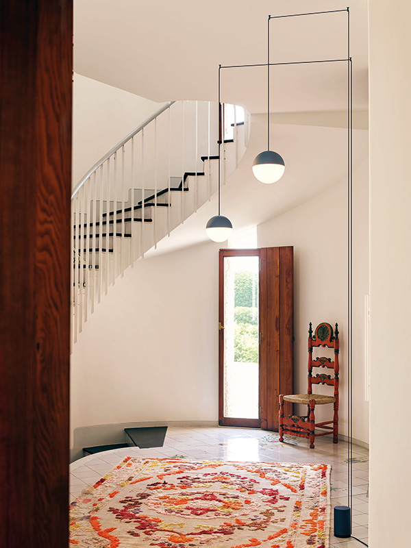 Flos String Light Sphere above a rug in a hallway