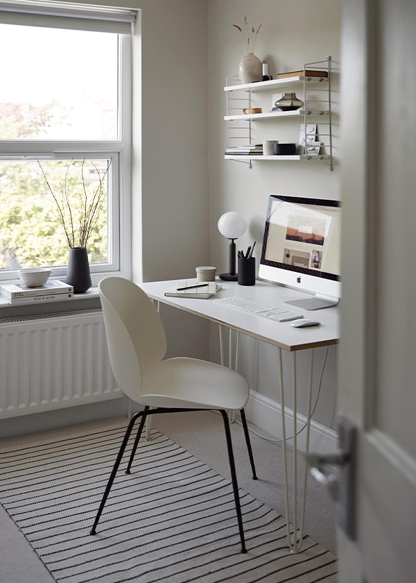 White Gubi Beetle Chair being used a desk chair in a minimal home office