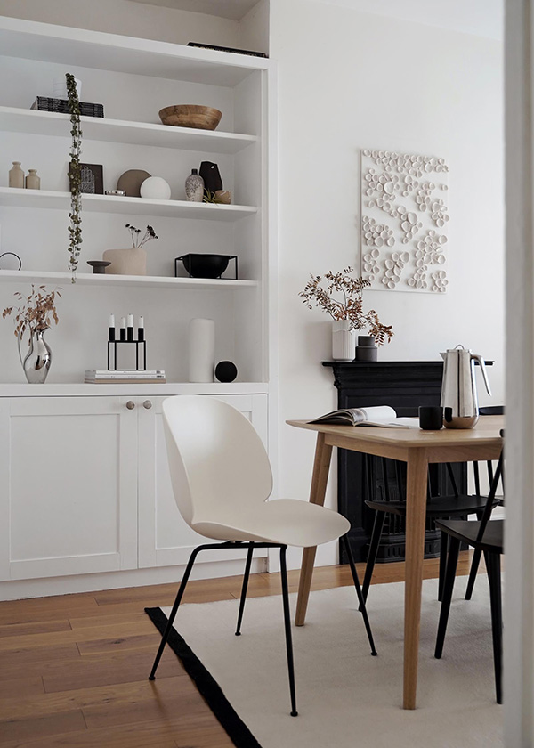 White Gubi Beetle Chair at the end of a wooden dining table