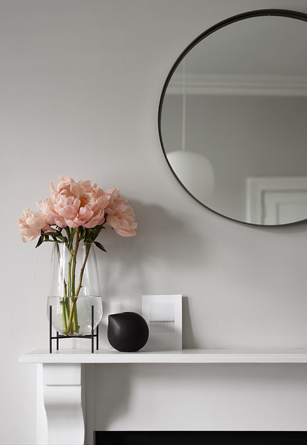Echasse Vase filled with pink flowers on a fireplace
