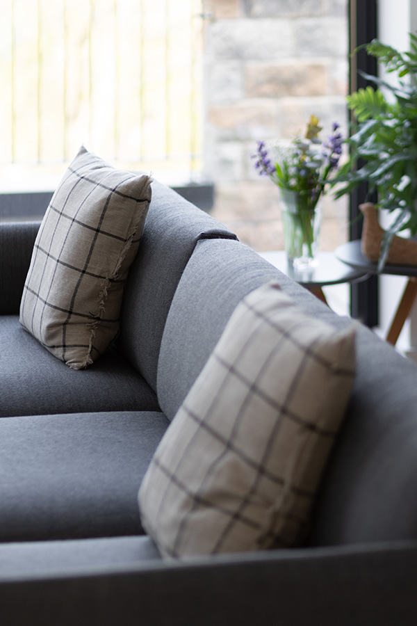 A close up of the Muuto Outline Sofa with Ferm Living Calm Cushions on