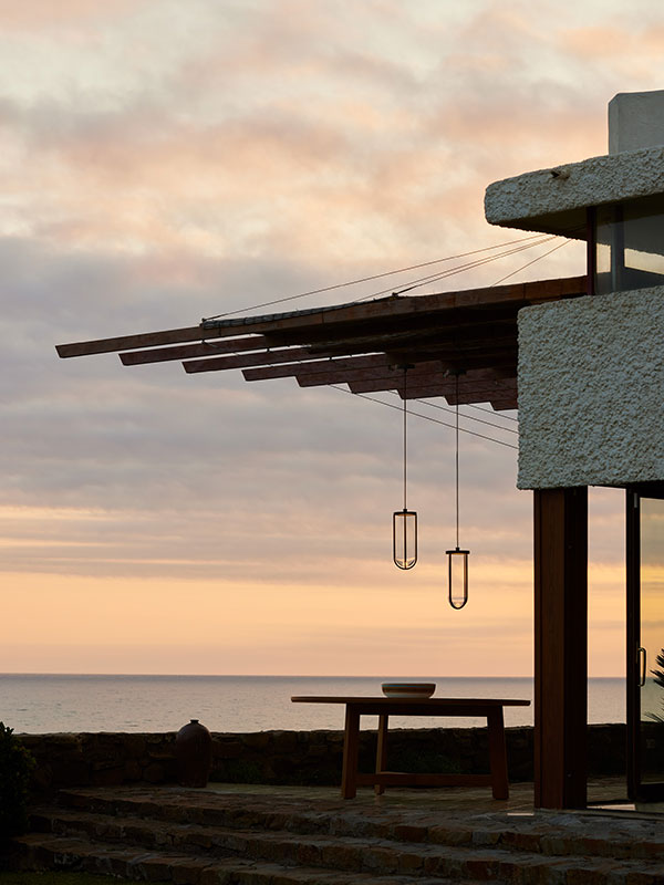 Two Flos In Vitro outdoor suspension lights hanging from the terrace of a modernist house