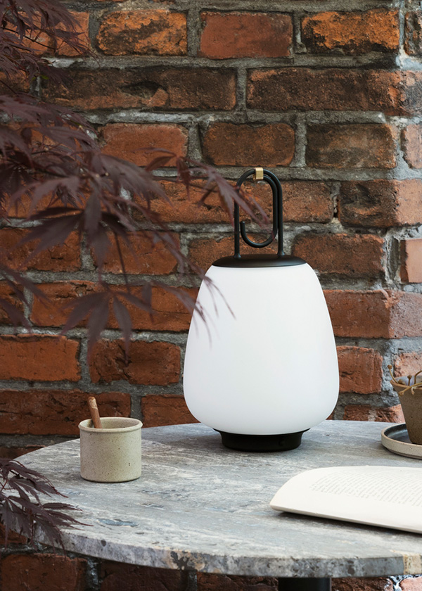 &Tradition Lucca Table Lamp on a grey marble table, in front of a brick wall