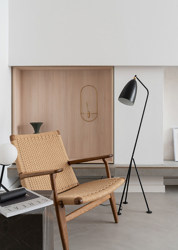 A minimal lounge nook featuring a CH25 Lounge Chair and Grashoppa Floor Lamp