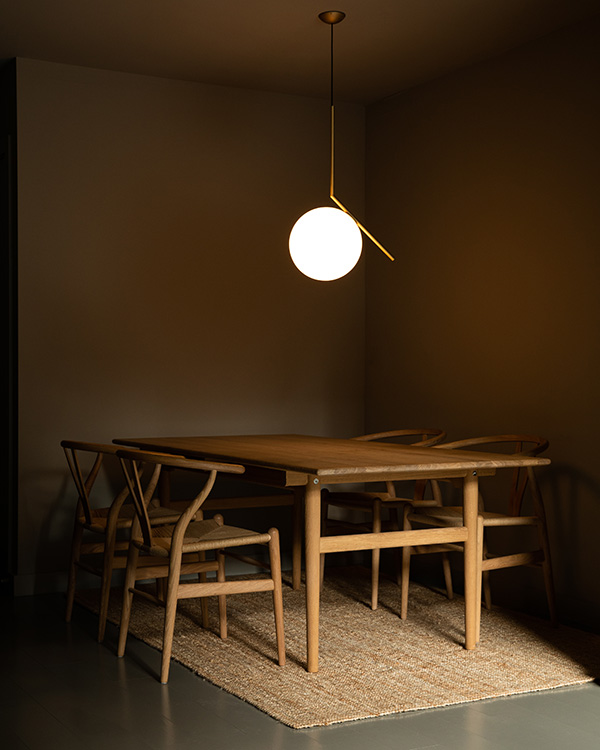 A dining space featuring CH24 wishbone chairs and a Flos IC S2 Pendant