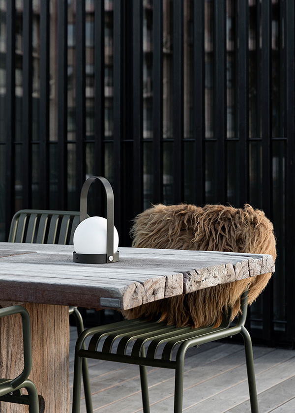 Audo Copenhagen Carrie Lamp on a wooden outdoor dining table