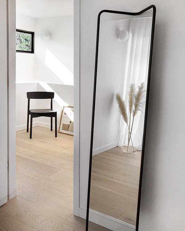 The Audo Copenhagen Kaschkasch floor mirror and black chair