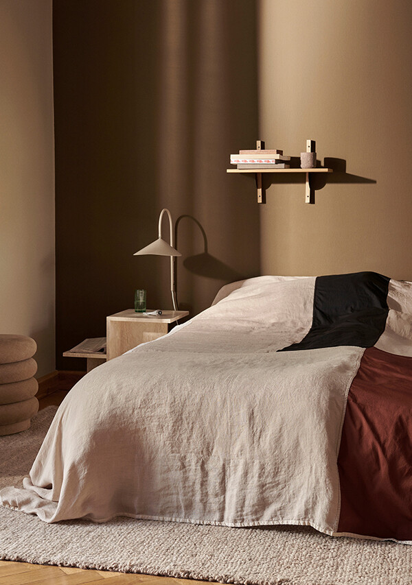 ferm LIVING Arum Wall Lamp beside a bed