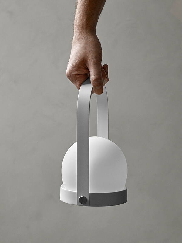 Audo Carrie LED Table Lamp carried by its handle