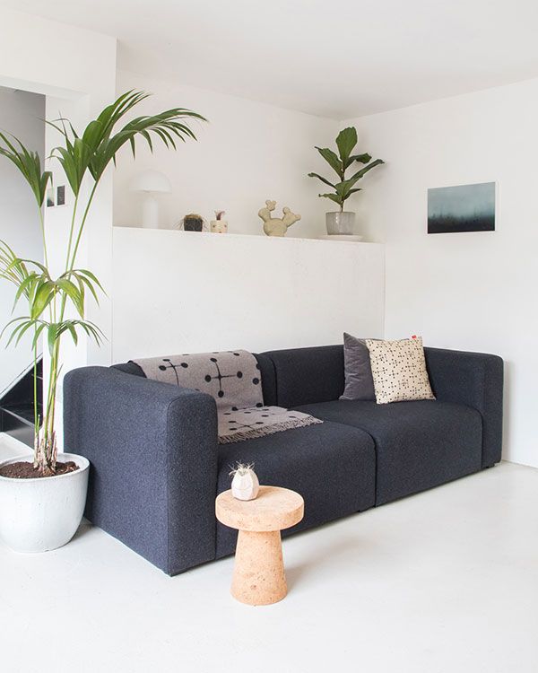 A dark grey Hay Mags sofa in a minimal living room