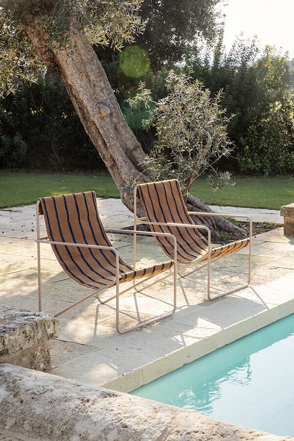 2 Ferm Living Desert Lounge chairs by the side of a pool