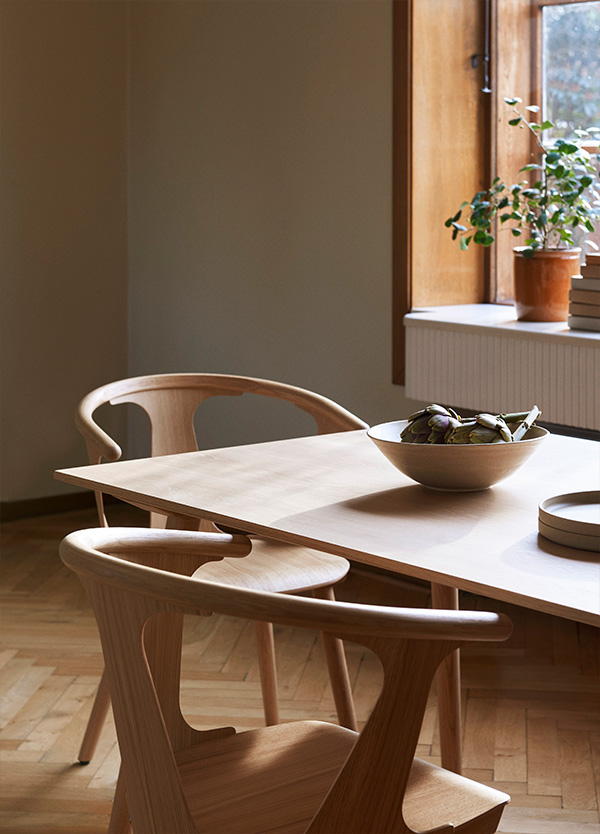 A close up of the &Tradition In Between Chairs around a wooden dining table