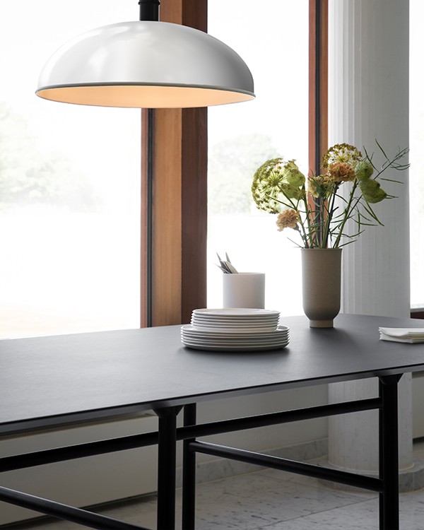 Audo Copenhagen Snaregade Table, with an overhanging light and a pot of flowers on the tabletop