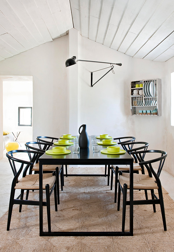 Flos 265 wall light above a dining table with wishbone chairs
