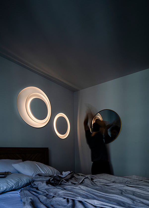 2 Foscarini Bahia wall lamps above a bed