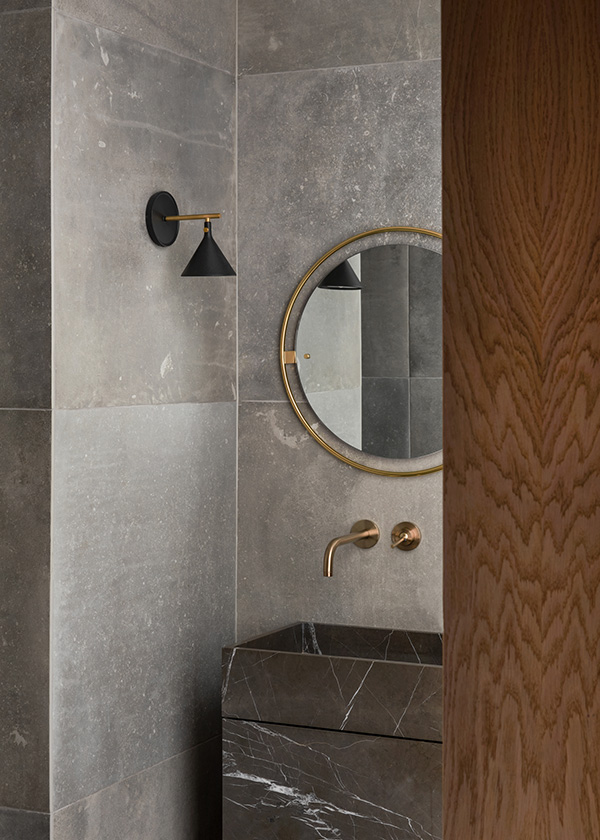 Audo Copenhagen Cast wall sconce next to a bathroom mirror