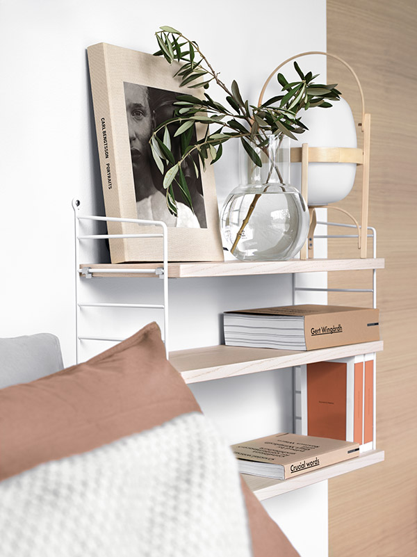 String Pocket shelving styled with books and a lamp