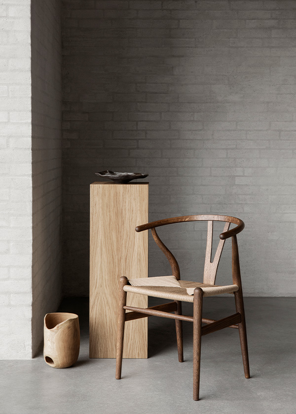 The CH24 wishbone chair in smoked oiled oak, next to a wooden podium