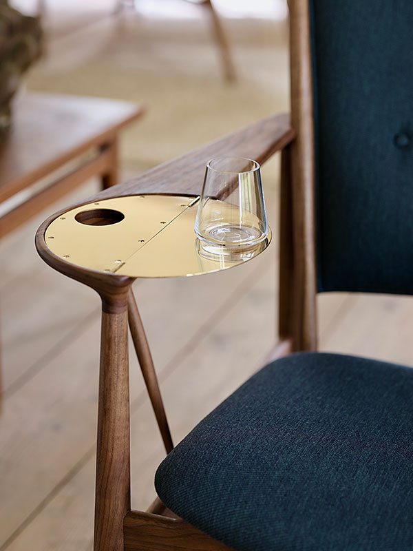 A close up of the brass arm tray on the Hosue of Finn Juhl Whisky Chair
