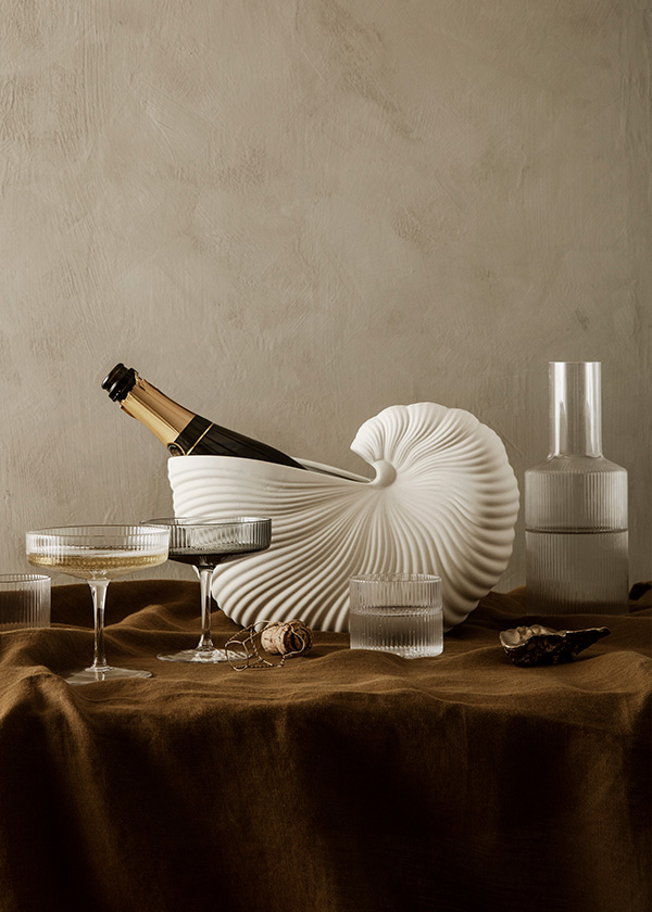 A Ferm Living shell pot being used as a champagne cooler