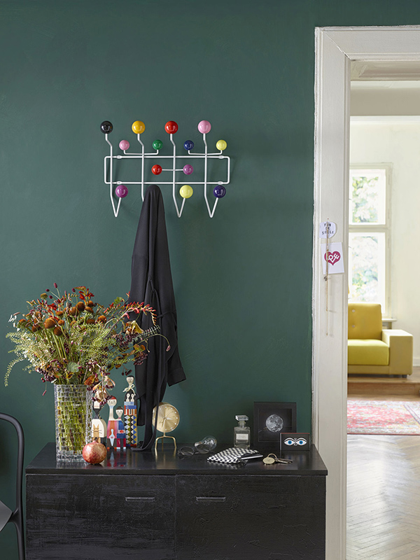 An Eames Hang It All in a dark green hallway