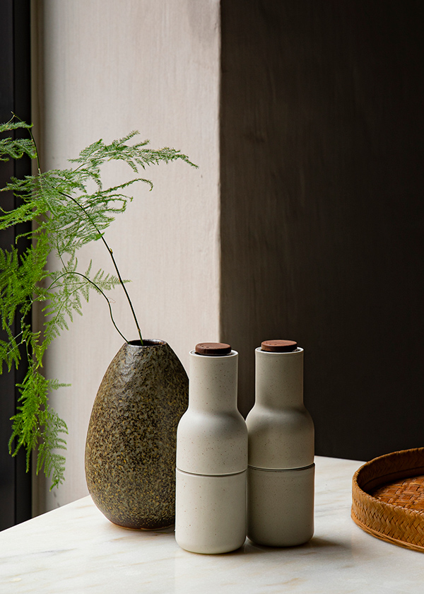 Menu Bottle Grinders in front of a plant pot
