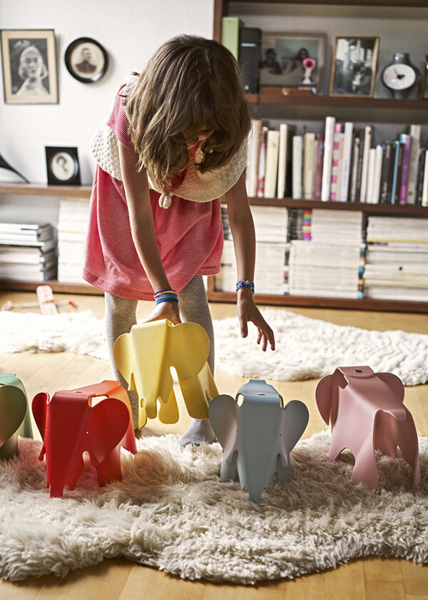 A child playing with a set of small Eames Elephants