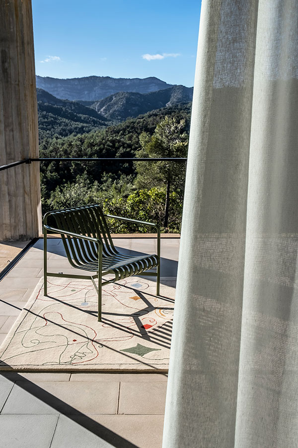 A Hay Palissade Lounge Chair and Nanimarquina outdoor Silhouette rug on an outdoor terrace