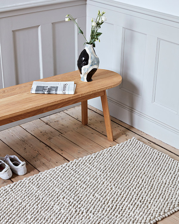 The Hay Peas Rug next to a wooden bench